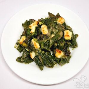 Penne di grano saraceno con spinaci e primosale in piatto bianco